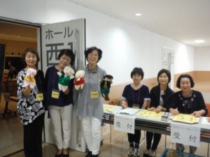 前橋ボランティア連絡会・桂萱読み聞かせの会「はぐはぐ」メンバーと人形が笑顔で迎えています